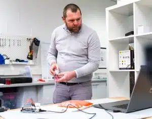 A Design Engineer testing a prototyped connected device concept with PCB board and medical device