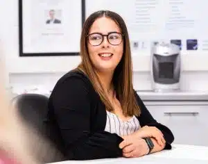 Commercial & Operations Coordinator, Kathryn seated in front of Haughton Design's product & medical device development workflow