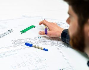 Design development engineer assessing medical device engineering drawings to reduce manufacturing costs